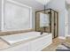 Bright bathroom featuring a soaking tub with jets and tiled walk-in shower with glass door at 13114 Long Common Pkwy, Huntersville, NC 28078