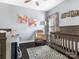Bedroom featuring a crib, glider chair, and butterfly-themed wall art at 13114 Long Common Pkwy, Huntersville, NC 28078