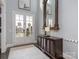 Bright foyer features a decorative mirror, area rug, and stylish cabinet with double doors leading to the outside at 13114 Long Common Pkwy, Huntersville, NC 28078