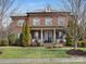 Beautiful two-story brick home with a manicured lawn and inviting front porch with classic architectural details at 13114 Long Common Pkwy, Huntersville, NC 28078