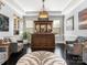 Entertainment room with a bar and a chandelier, complemented by neutral walls and dark hardwood floors at 13114 Long Common Pkwy, Huntersville, NC 28078