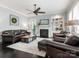 Living room featuring a fireplace, ceiling fan, and comfortable leather seating at 13114 Long Common Pkwy, Huntersville, NC 28078