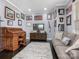 Cozy office with a roll-top desk, comfortable sofa, wood floors, an area rug, and multiple wall decorations at 13114 Long Common Pkwy, Huntersville, NC 28078
