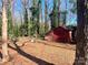 Charming red backyard shed surrounded by mature trees in a serene outdoor setting at 1610 India Hook Rd # 26, Rock Hill, SC 29732