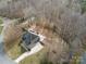 Overhead aerial showcasing the home's backyard patio, long driveway, and plentiful mature trees at 2100 Winding Oaks Trl, Waxhaw, NC 28173