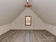 Finished attic space with vinyl flooring and a small window at 2100 Winding Oaks Trl, Waxhaw, NC 28173
