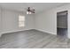 Bright bedroom featuring gray flooring, neutral walls, a ceiling fan, and a window for natural light at 2100 Winding Oaks Trl, Waxhaw, NC 28173