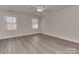 Bright bedroom featuring gray flooring, neutral walls, two windows, and a ceiling fan at 2100 Winding Oaks Trl, Waxhaw, NC 28173