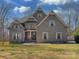 Stunning two-story traditional home with beautiful gray brick facade and lush front yard at 2100 Winding Oaks Trl, Waxhaw, NC 28173