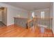 Hallway with hardwood floors and wooden railing at 2100 Winding Oaks Trl, Waxhaw, NC 28173