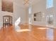 Bright living room with fireplace, hardwood floors, decorative trim, and staircase access at 2100 Winding Oaks Trl, Waxhaw, NC 28173
