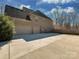 Side view of brick home featuring an attached three-car garage and expansive parking area at 2100 Winding Oaks Trl, Waxhaw, NC 28173