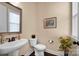 Stylish powder room with pedestal sink, decorative mirror, and dark wood flooring at 2172 Paddlers Cove Dr, Clover, SC 29710