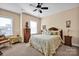 A serene bedroom with a wooden bed frame, matching furniture, a ceiling fan, and natural light from the window at 2172 Paddlers Cove Dr, Clover, SC 29710