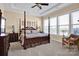 A bedroom with a tray ceiling, ceiling fan, and a four-poster bed sits in front of a bright window at 2172 Paddlers Cove Dr, Clover, SC 29710