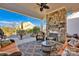 A covered patio has a stone fireplace, comfortable seating, and a view of the backyard at 2172 Paddlers Cove Dr, Clover, SC 29710