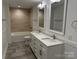 Modern bathroom featuring a double vanity, white cabinets, and a tiled shower and tub at 3332 Draper Ave, Charlotte, NC 28205
