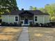 Charming single-story home featuring stone accents, a blue front door, and a well-manicured front yard at 3332 Draper Ave, Charlotte, NC 28205