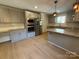 Modern gray kitchen with stainless steel appliances, granite countertops, and stylish overhead lighting at 3332 Draper Ave, Charlotte, NC 28205