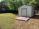 A backyard metal storage shed sits on a wooden platform in a fenced yard at 3332 Draper Ave, Charlotte, NC 28205