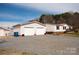 Detached two-car garage with white doors and gravel driveway at 3991 Bunker Hill School Rd, Claremont, NC 28610