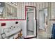 Compact bathroom featuring a shower, sink, and vintage patterned wallpaper at 401 N Inman Ave, Bessemer City, NC 28016