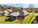 View of brick home featuring a screened-in porch and well-maintained lawn with mature trees in a landscaped backyard at 4405 Zee Ct, Monroe, NC 28110