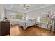 Bright bedroom features tray ceilings, ceiling fan, hardwood floors, and two windows at 4405 Zee Ct, Monroe, NC 28110
