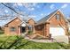 Well-kept brick home featuring a manicured lawn, charming garden beds, and a two-car garage at 4405 Zee Ct, Monroe, NC 28110