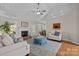 Cozy living room with fireplace, white sofas, a blue ottoman, and an open kitchen view at 4405 Zee Ct, Monroe, NC 28110