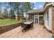 Brick patio with outdoor dining, leading to screened porch and a backyard playset at 4739 Binfords Ridge Rd, Charlotte, NC 28226