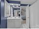 Stylish blue bathroom with white vanity, bright lighting, and a view to the bedroom at 4739 Binfords Ridge Rd, Charlotte, NC 28226