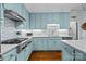 Beautiful kitchen features light blue cabinets, white backsplash, and stainless steel appliances at 4739 Binfords Ridge Rd, Charlotte, NC 28226