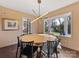 Sunlit dining room featuring a round table, modern light fixture, and a large bay window at 605 Heathermoor Ct, Charlotte, NC 28209