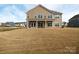 Large, open backyard with covered patio, surrounded by other residential houses and a lush lawn at 611 Yucatan Dr, Waxhaw, NC 28173