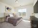 Bright bedroom with a large window, neutral-toned walls, carpet, and stylish furnishings at 611 Yucatan Dr, Waxhaw, NC 28173