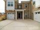 This home's entrance showcases an elegant doorway framed by white pillars and access to attached two-car garage at 611 Yucatan Dr, Waxhaw, NC 28173