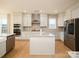 Bright kitchen with granite countertops, stainless steel appliances, an island, and hardwood floors is great for cooking at 611 Yucatan Dr, Waxhaw, NC 28173