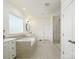 Bright main bathroom featuring a soaking tub, tiled floors, and glass enclosed shower at 611 Yucatan Dr, Waxhaw, NC 28173