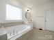 Bright main bathroom featuring soaking tub, single vanity, and large window at 611 Yucatan Dr, Waxhaw, NC 28173