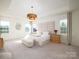 Bright main bedroom featuring tray ceiling, gold light fixture, and plush, padded headboard at 611 Yucatan Dr, Waxhaw, NC 28173