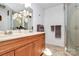 Modern bathroom with a double sink vanity, decorative shower door, and neutral accents creating a clean, serene space at 9307 Raintree Ln, Charlotte, NC 28277