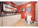 Red bathroom featuring a large mirror, white vanity, and tiled floor at 940 N New Hope Rd, Gastonia, NC 28054