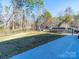 Spacious, fenced backyard with mature trees, playground equipment, and boat, perfect for Gathering activities and outdoor enjoyment at 1004 Loganberry Ln, Salisbury, NC 28146