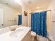 Clean bathroom with a white vanity, mirror, and a shower with decorative blue curtains at 1004 Loganberry Ln, Salisbury, NC 28146