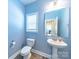 Powder room features a pedestal sink, toilet, and mirror with a view into the mudroom at 1004 Loganberry Ln, Salisbury, NC 28146