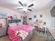 Cozy bedroom with ceiling fan, vanity desk, and colorful decor creates a playful and inviting atmosphere at 1004 Loganberry Ln, Salisbury, NC 28146