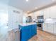 Modern kitchen with stainless steel appliances, white cabinets, blue island, and wood grain flooring at 1004 Loganberry Ln, Salisbury, NC 28146