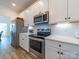 Well-lit kitchen features stainless steel appliances, white cabinets, and a tile backsplash at 1004 Loganberry Ln, Salisbury, NC 28146