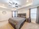 Relax in this main bedroom with a ceiling fan, a tray ceiling and a king bed with built-in storage at 1004 Loganberry Ln, Salisbury, NC 28146